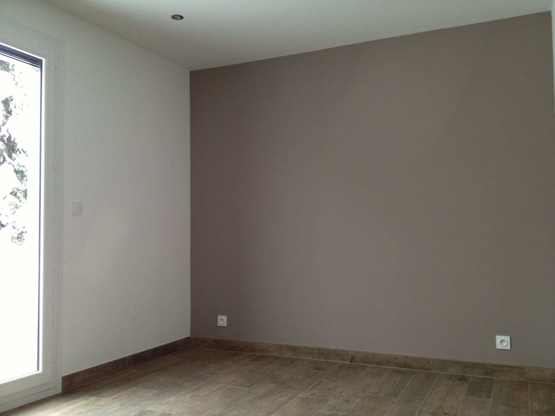 Pièce avec murs peints de couleurs différentes, en gris et en blanc.