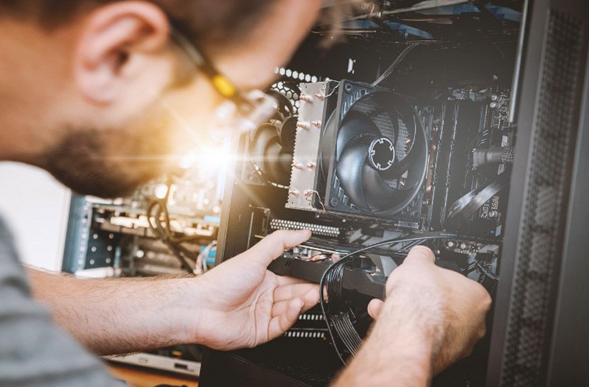 Persona instalando un componente informático dentro de la carcasa de un ordenador de sobremesa.