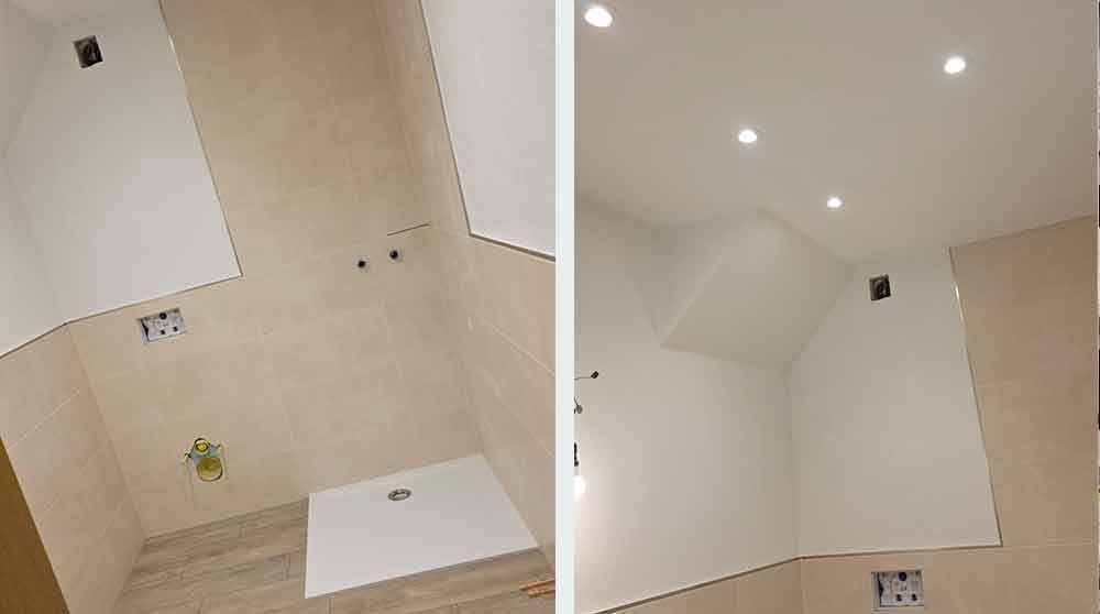 Leere geflieste Duschkabine mit beigen Wänden, weißer Duschtasse und Einbauspots in der Decke.