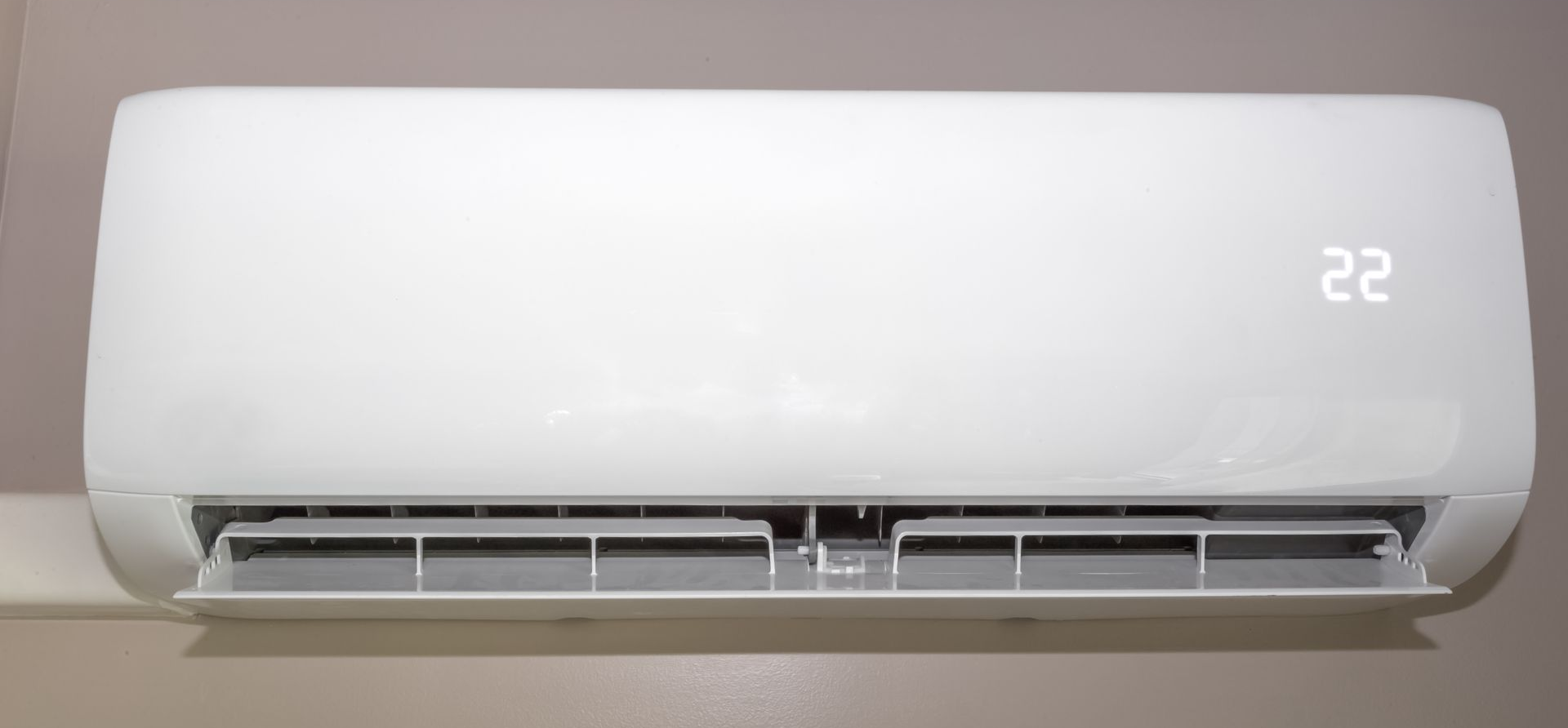 Climatiseur mural blanc affichant la température 22.