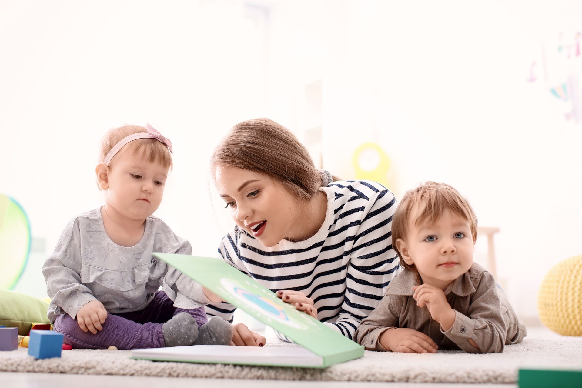 Deux enfants avec une adulte et un livre