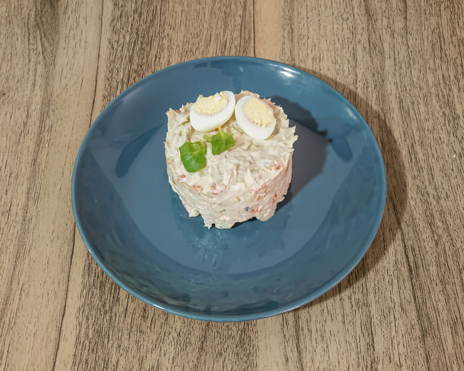 Un pequeño trozo de comida en un plato azul sobre una mesa de madera.