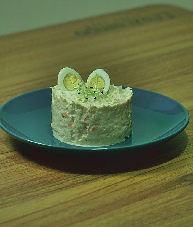 Un pequeño trozo de comida en un plato azul sobre una mesa de madera.