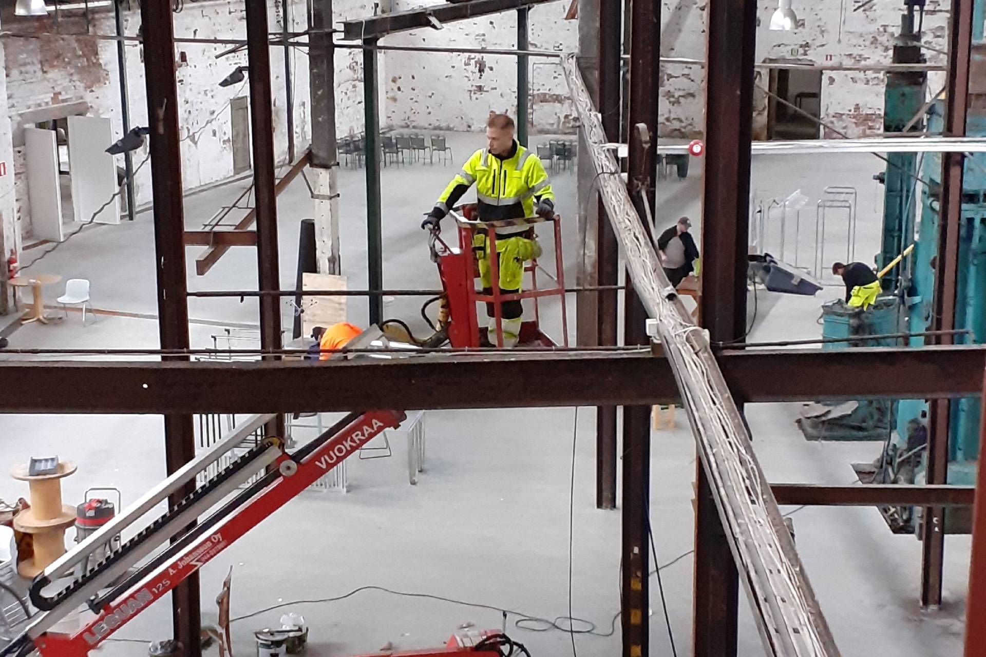 Sähkömies seisoo henkilönostimessa