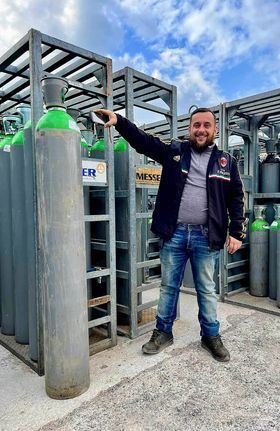 Homme debout à côté d'une bouteille de co2