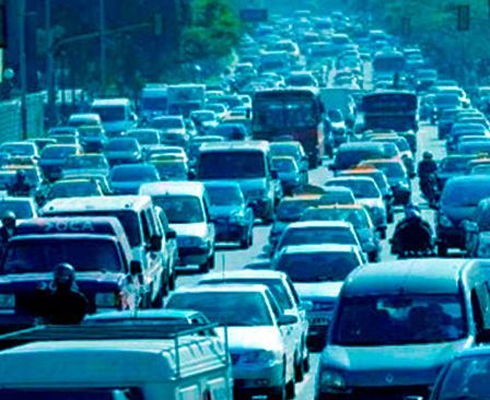 Gran atasco en una carretera de varios carriles con muchos coches y camiones bajo un tinte azul.