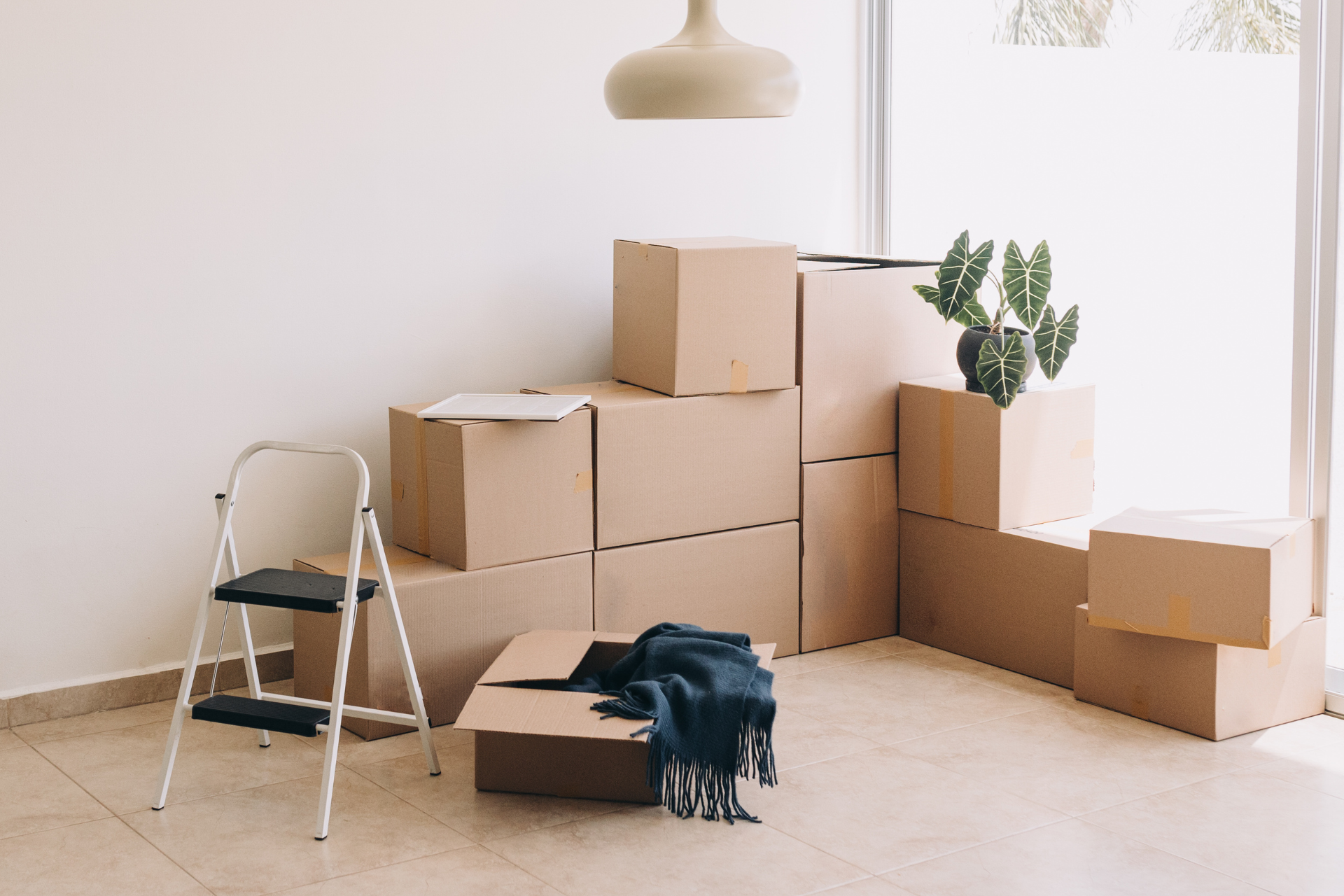 Una habitación llena de cajas de cartón y una escalera.