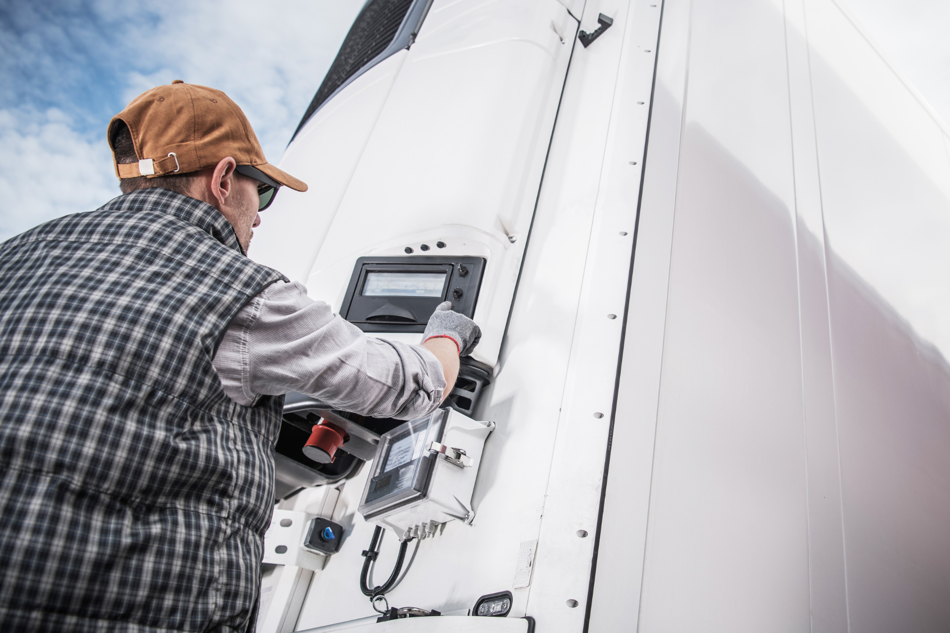 Un hombre está trabajando en un camión blanco.