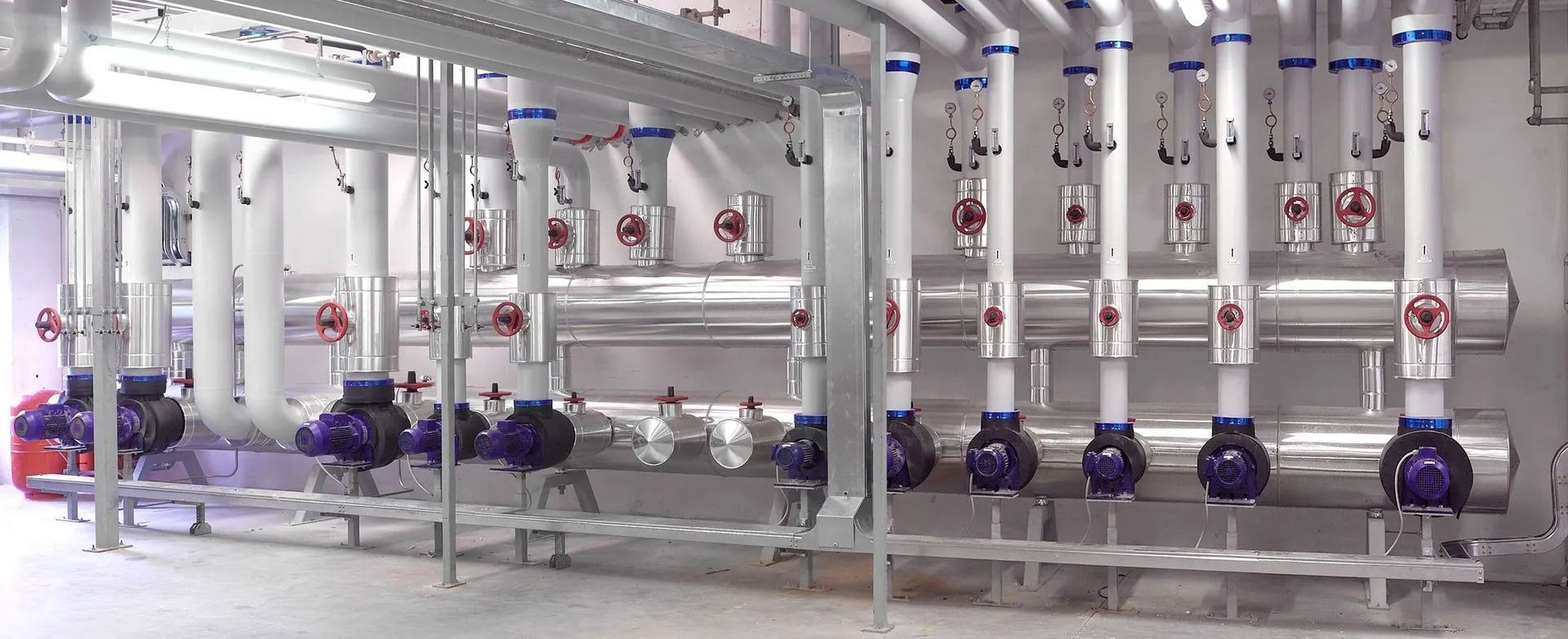 Complesso sistema di tubazioni industriali con pompe, valvole e tubi isolati