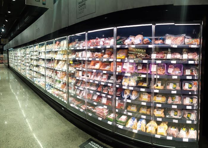 Un pasillo largo de una tienda de comestibles lleno de mucha comida.