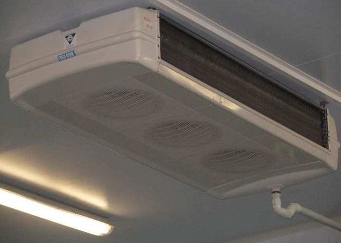 Un acondicionador de aire blanco cuelga del techo de una habitación.