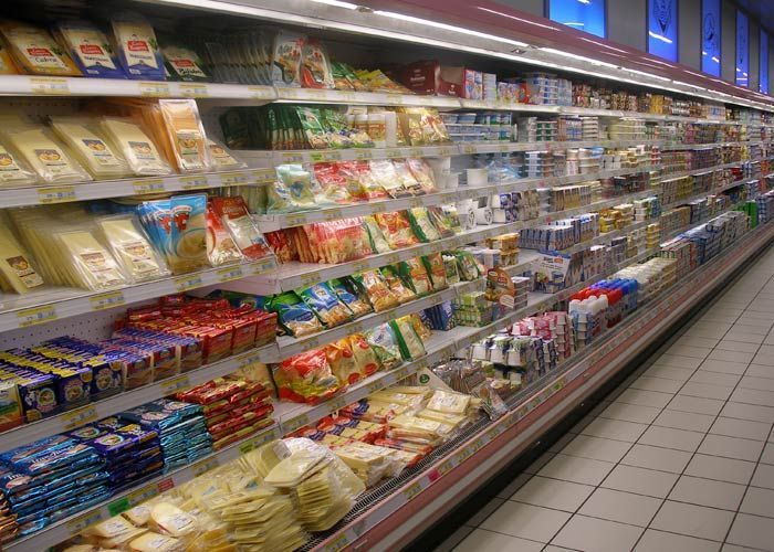 Un pasillo de una tienda de comestibles lleno de comida y bebidas.