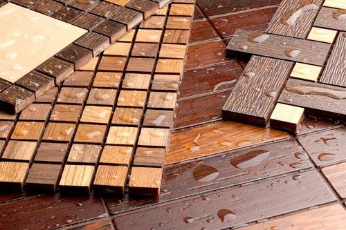 Un primer plano de un piso de madera con gotas de agua sobre él.