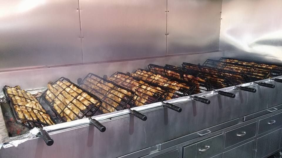 Un montón de comida se está cocinando en una parrilla en una cocina.