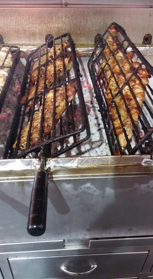 Un montón de comida se está cocinando en una parrilla.