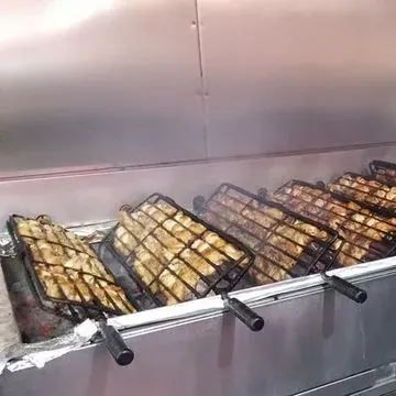 Un recipiente de aluminio lleno de costillas y papas fritas.