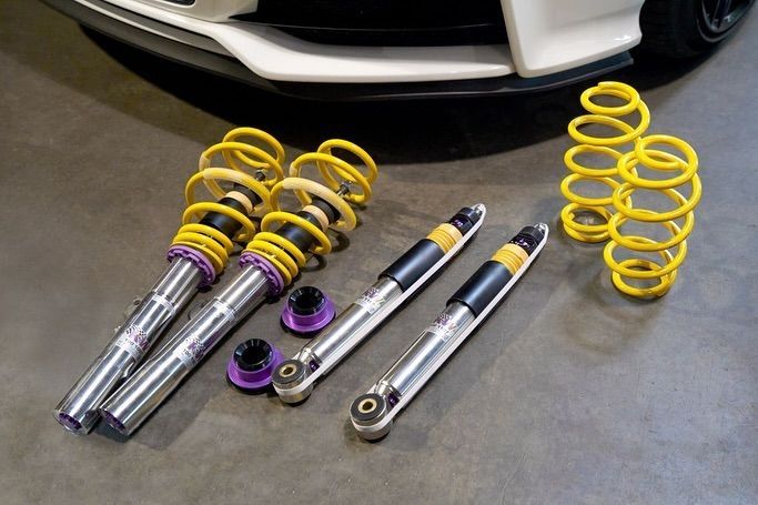 Un conjunto de amortiguadores y resortes se encuentran debajo de un automóvil.