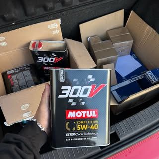 Una persona sostiene una lata de motul 5w-40.