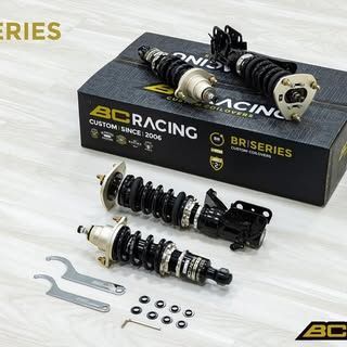 Un par de amortiguadores están encima de una caja que dice BC Racing.