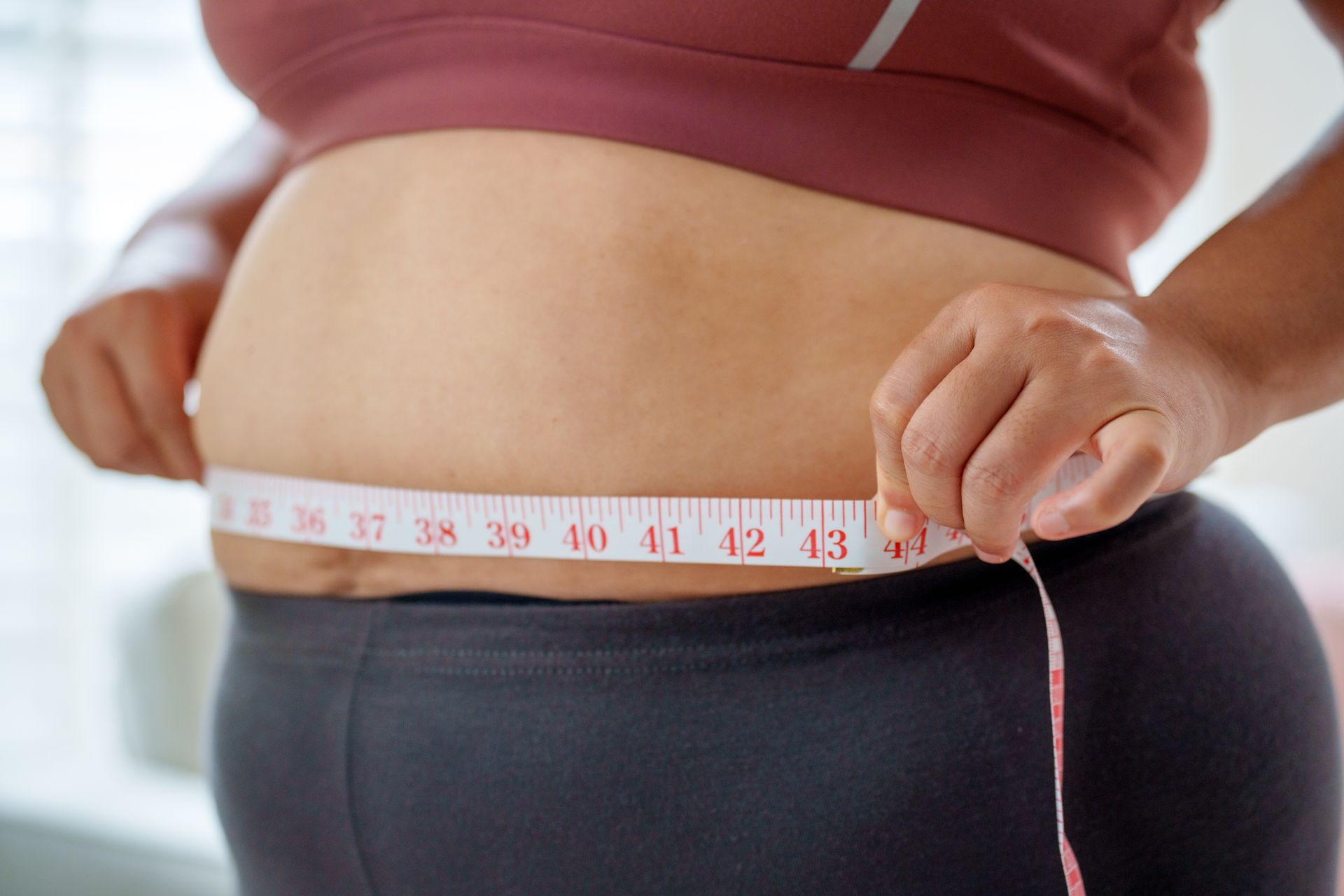 Mesure du tour de taille d'une personne à l'aide d'un ruban métrique.