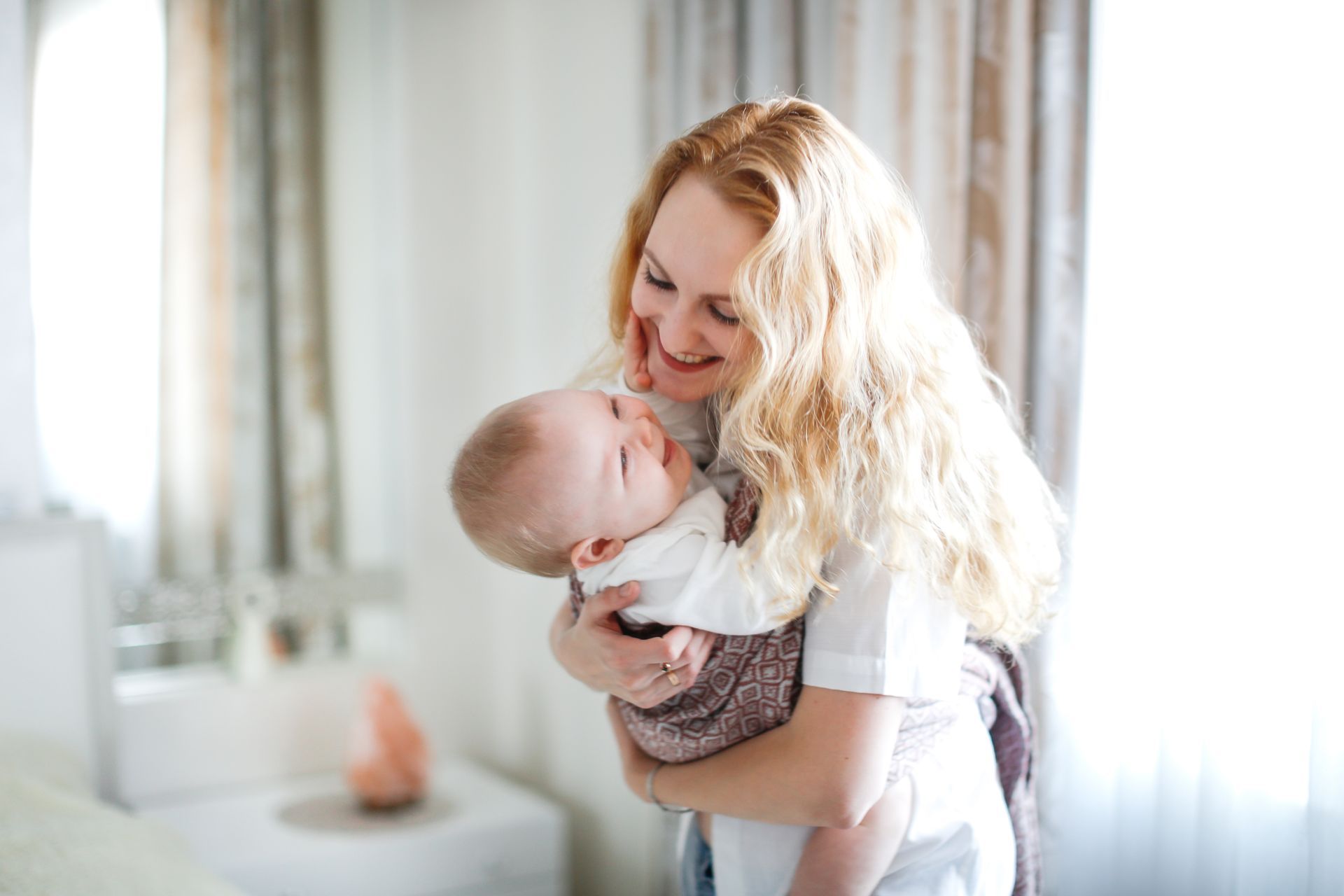 Une femme souriante tenant un enfant dans ses bras