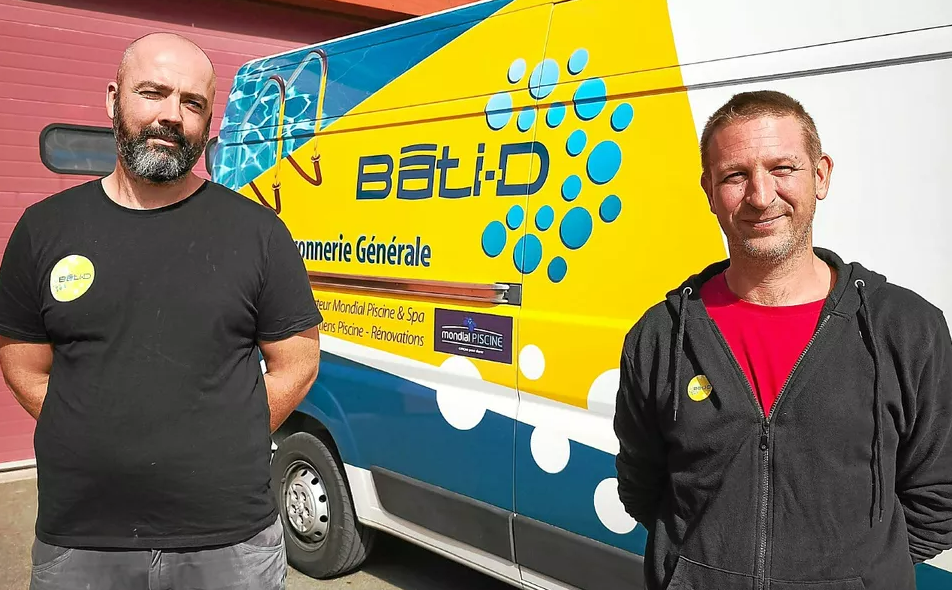 Deux hommes se tiennent à côté de la camionnette la société Bâti-D.