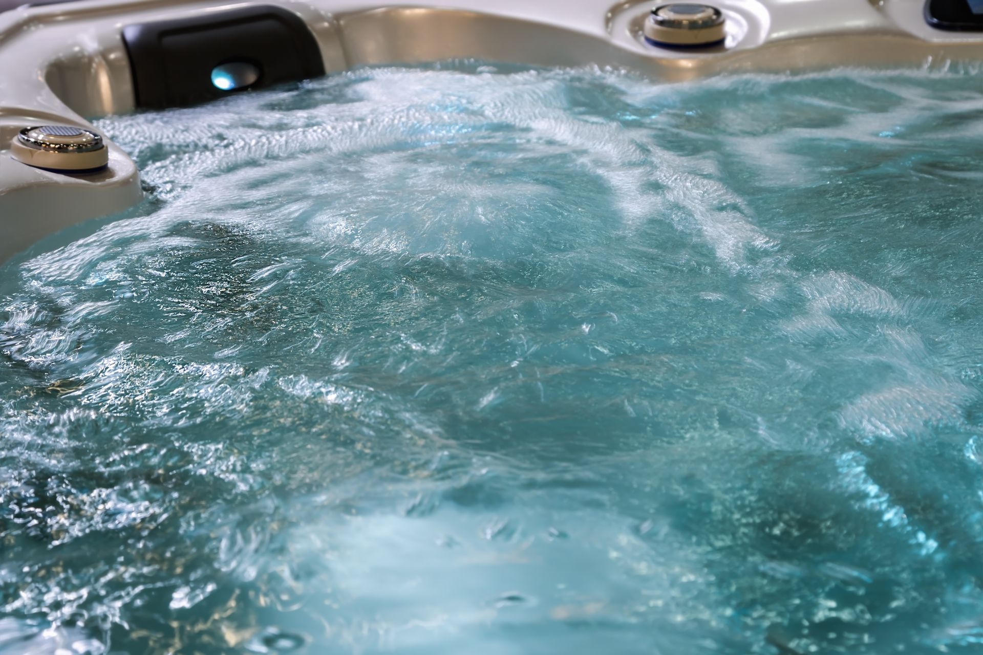 L'eau turquoise bouillonne dans un jacuzzi, les jets créant de la mousse.