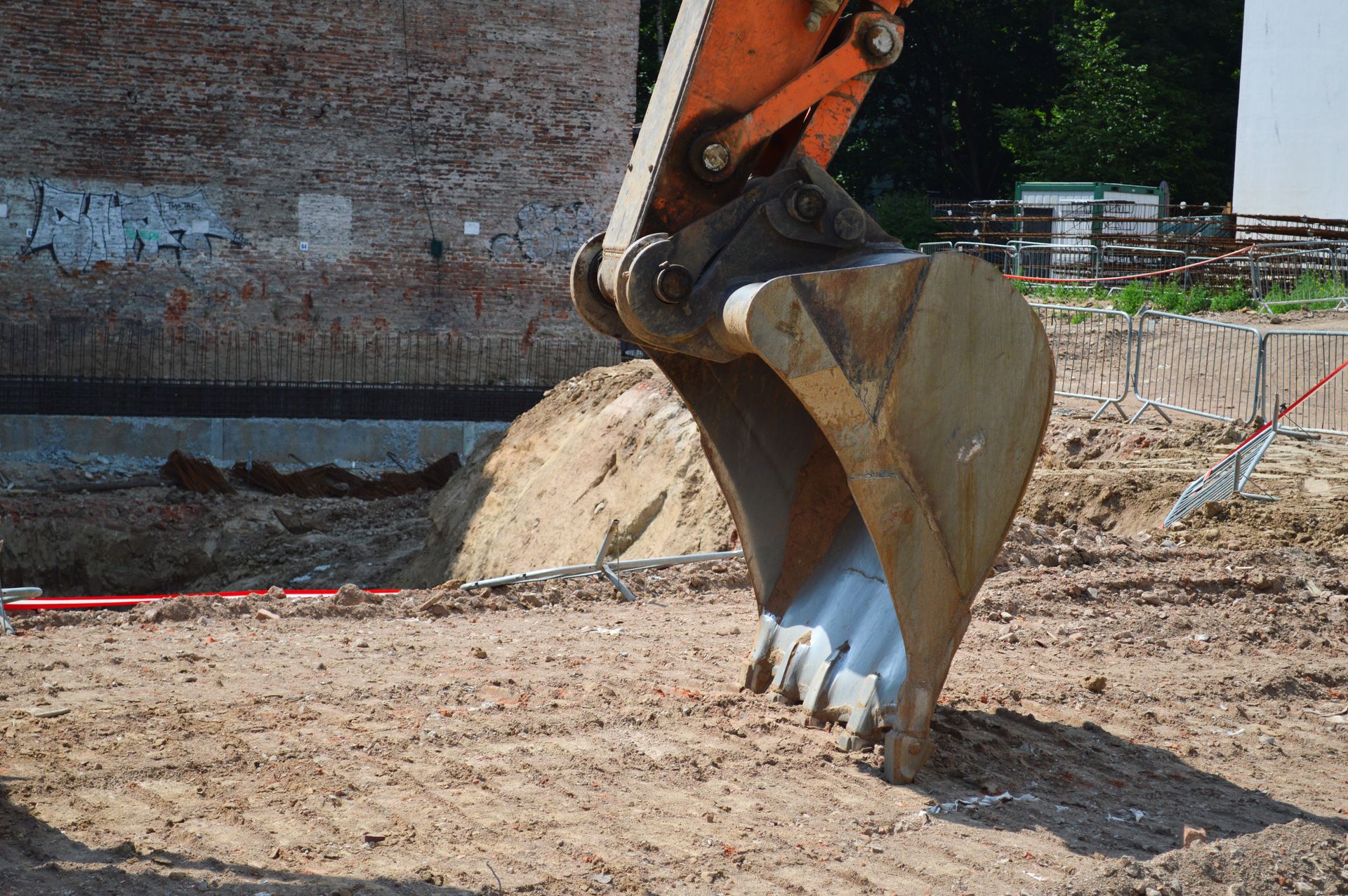 Le godet d'une excavatrice creuse la terre sur un chantier de construction.