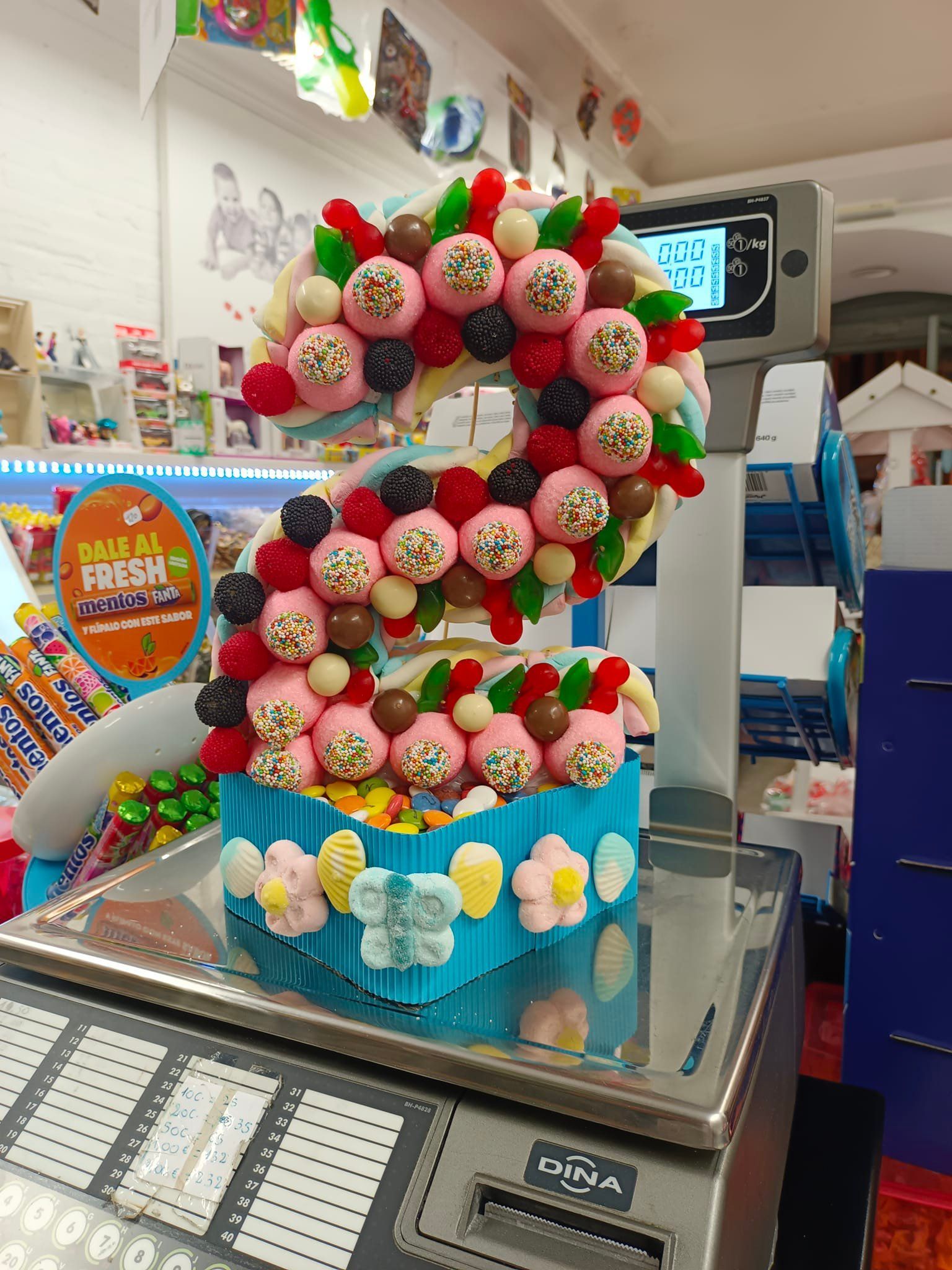 Un pastel con la forma del número seis está en una balanza.