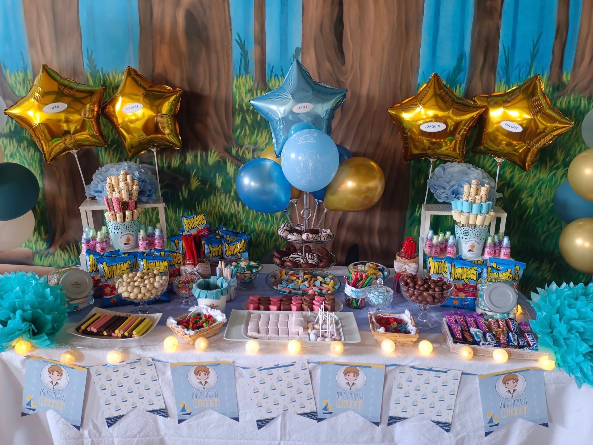 Una mesa con muchos dulces y globos encima.