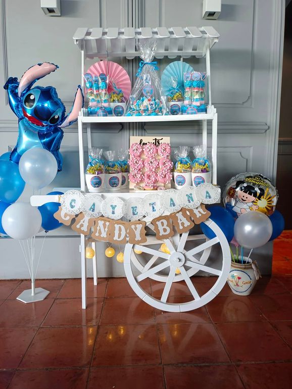 Un carrito de dulces decorado con globos y un globo cosido.