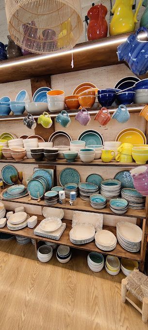 Un estante lleno de muchos cuencos y platos coloridos.