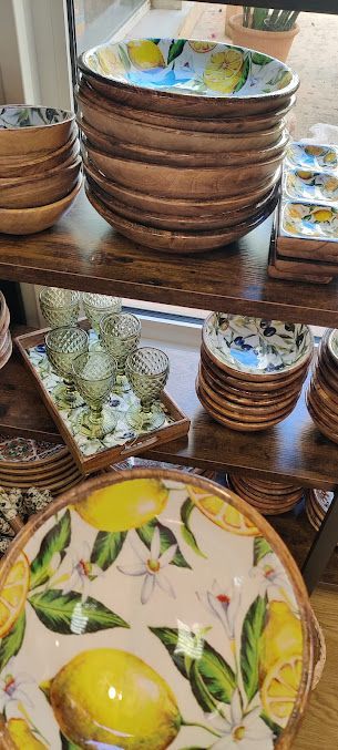 Un estante lleno de cuencos y platos con limones encima.