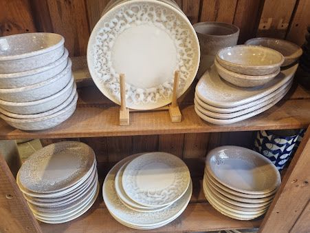 Un estante lleno de platos y cuencos en un estante de madera.