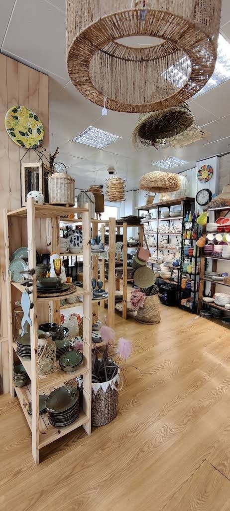 Una tienda llena de estantes y lámparas de mimbre.