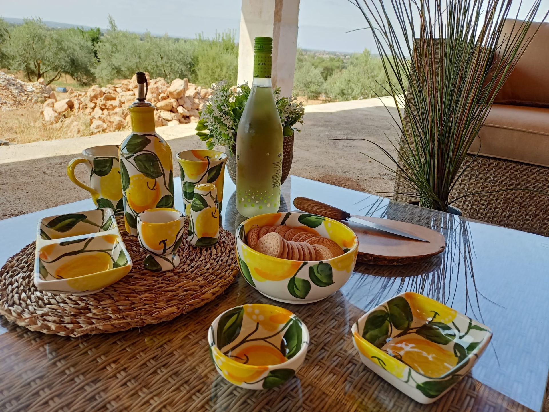 Una mesa con cuencos, tazas y una botella sobre ella.