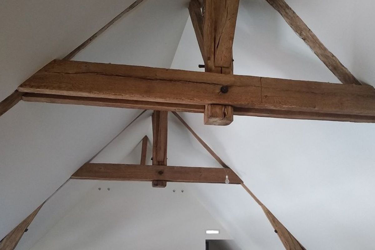 Poutres et fermes de toit en bois dans un grenier, sur fond de plafond blanc