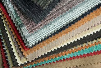 Muestras de tela en varios colores y texturas, dispuestas en abanico, mostrando opciones.