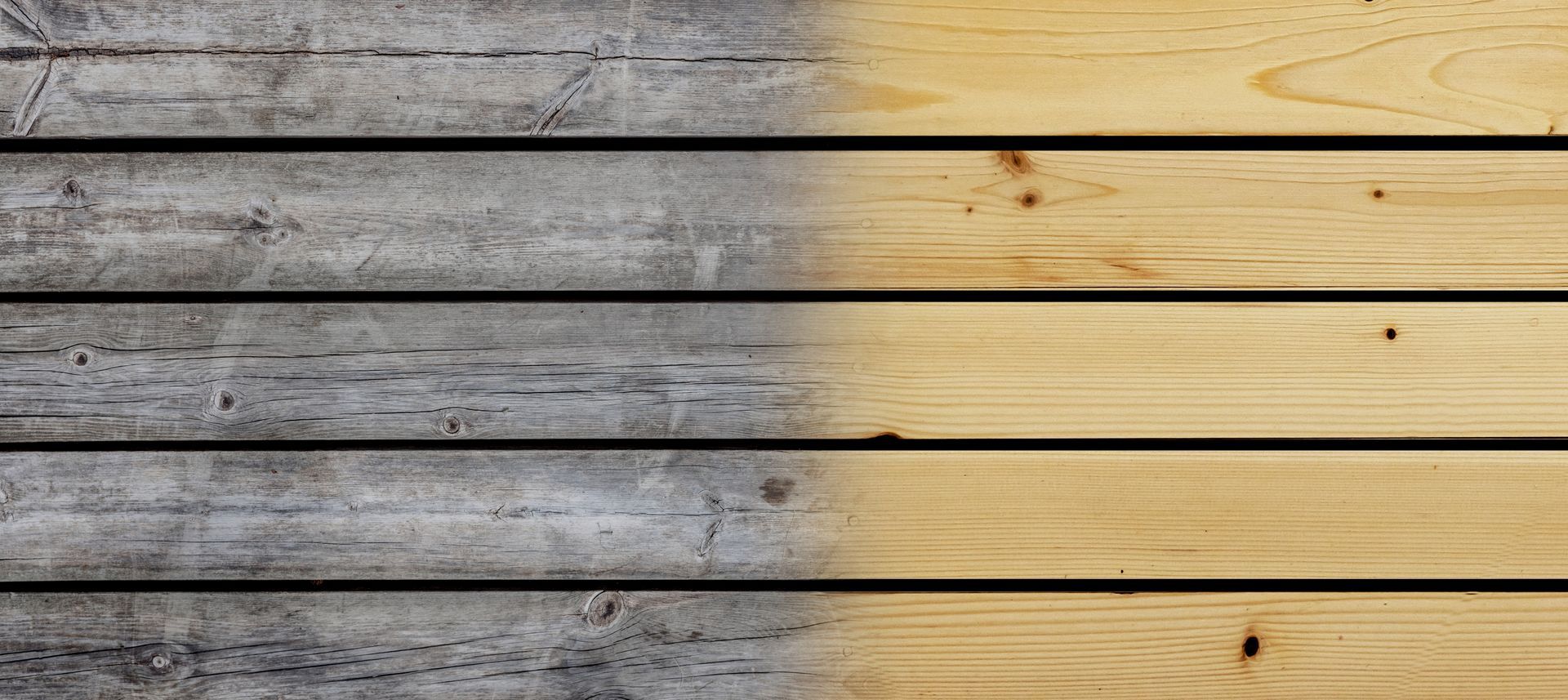 Planches en bois horizontales présentant une transition entre une surface grisée et une surface claire, avec des veines et nœuds visibles.