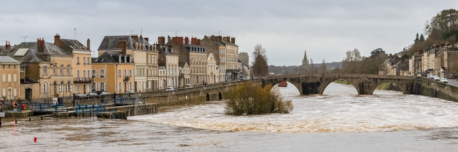 Vue d'une rivière traversant une ville, avec des bâtiments alignés le long des quais