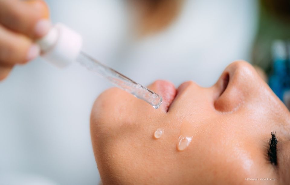 Pipette zum Auftragen von Serum auf das Gesicht einer Person während einer Hautpflegebehandlung