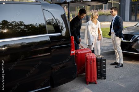 Une personne en costume protège de ses mains les icônes lumineuses d'un avion et d'un voyageur avec des bagages.
