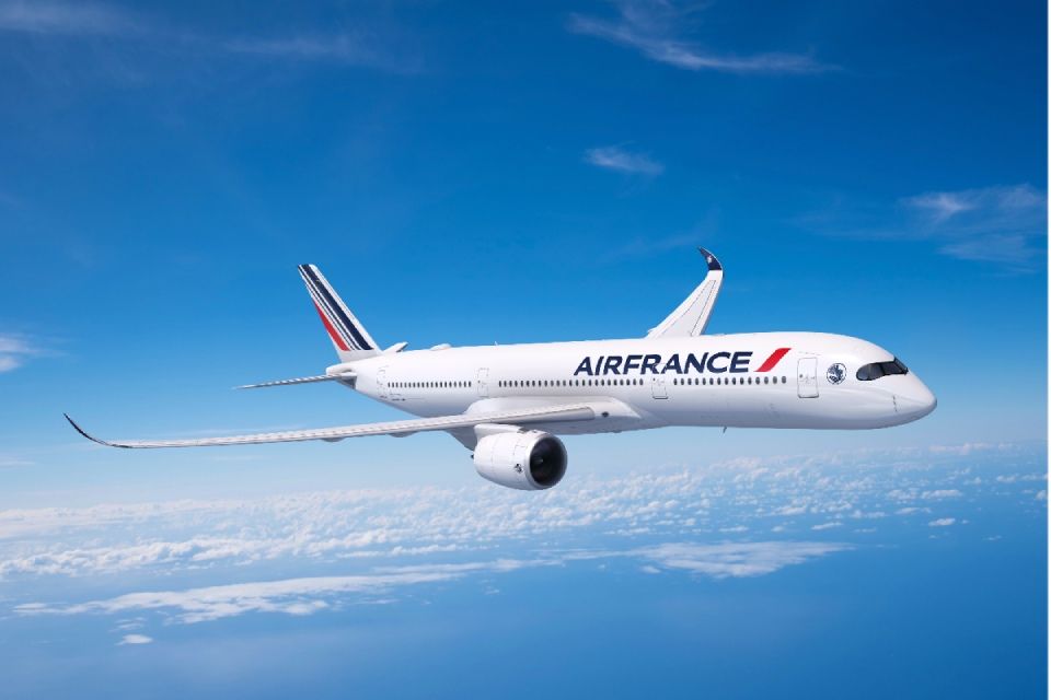 Un avion de ligne Air France survole les nuages dans un ciel bleu