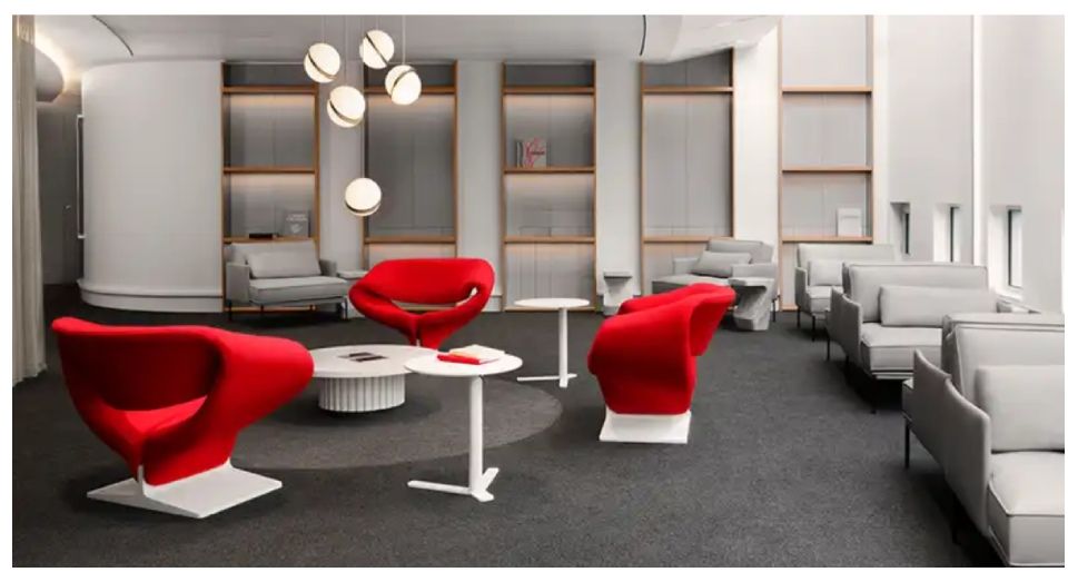 Salon moderne avec chaises rouges et grises, tables blanches et étagères intégrées dans un intérieur élégant.