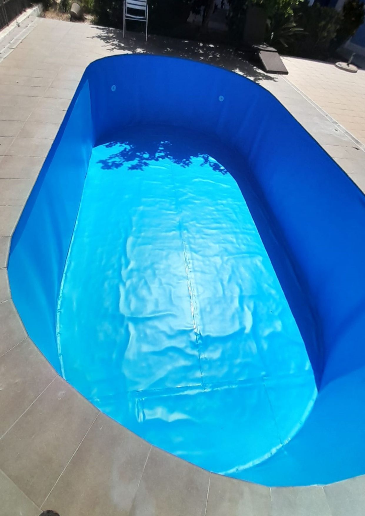 Una piscina con escaleras y una herramienta en el suelo.