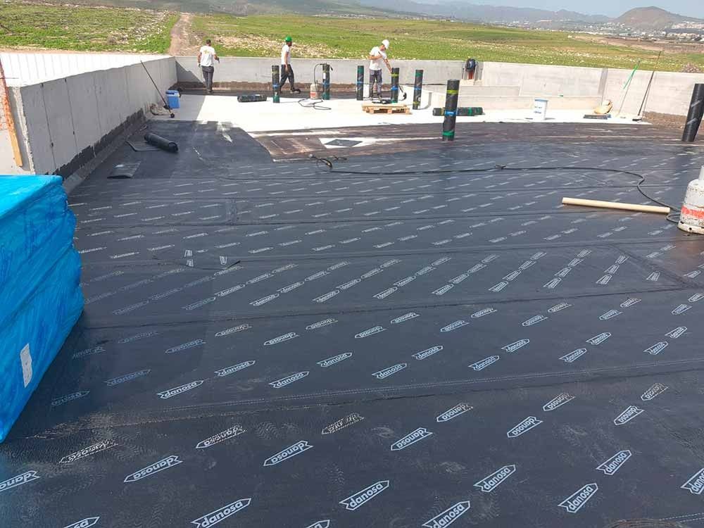 Un grupo de personas está trabajando en un tejado.