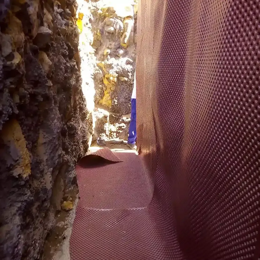 Una persona está parada en un callejón estrecho entre dos paredes.