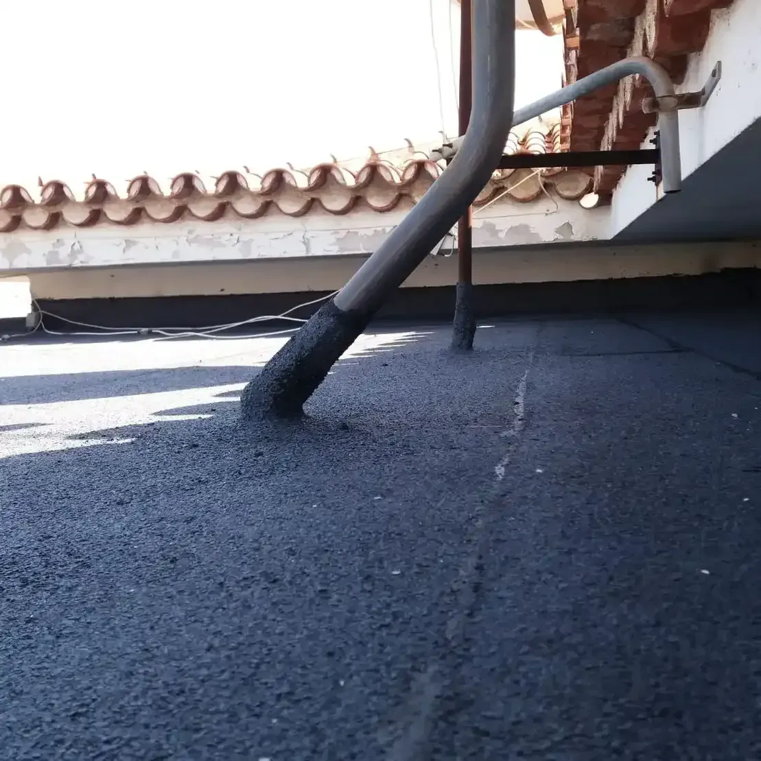 Un tubo de desagüe sale del techo de un edificio.