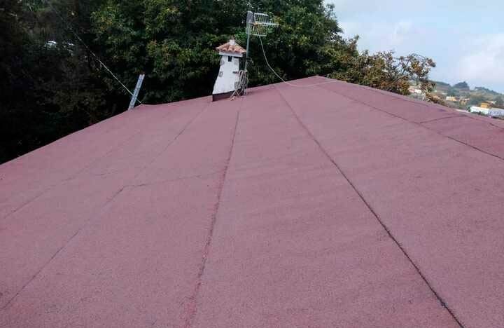 Un techo rojo con una chimenea encima.