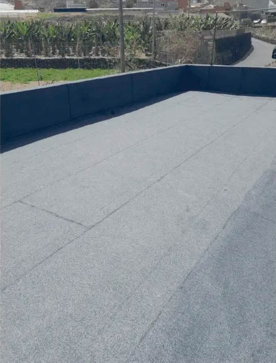 Un tejado con techo gris y una valla azul que lo rodea.